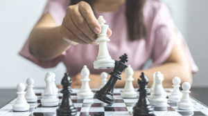 Businesswoman,holding,chess,to,take,down,opposing,players,,proactive,business